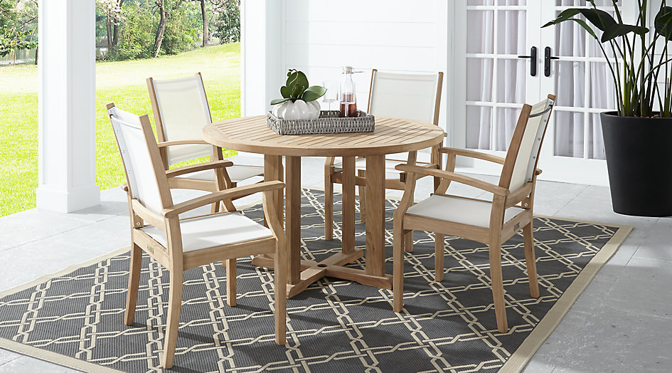 Picture of a teak 5 piece round outdoor dining set.