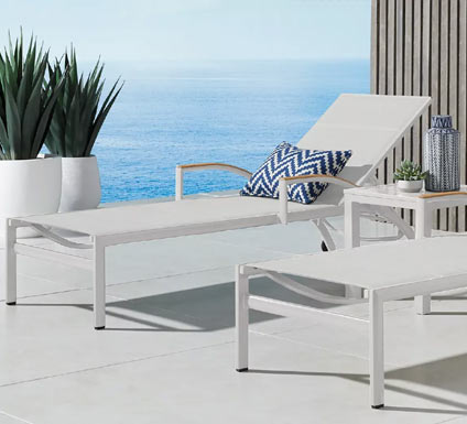 White backyard chaises with blue patterned accents.