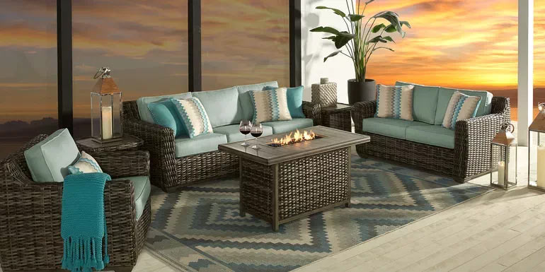 Photo of a brown wicker outdoor seating set and fire pit table