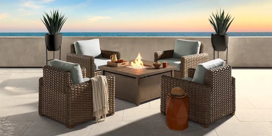Photo of four wicker patio chairs arranged around a fire pit table