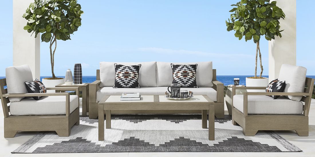 Photo of wooden outdoor seating set with beinge cushions and tables