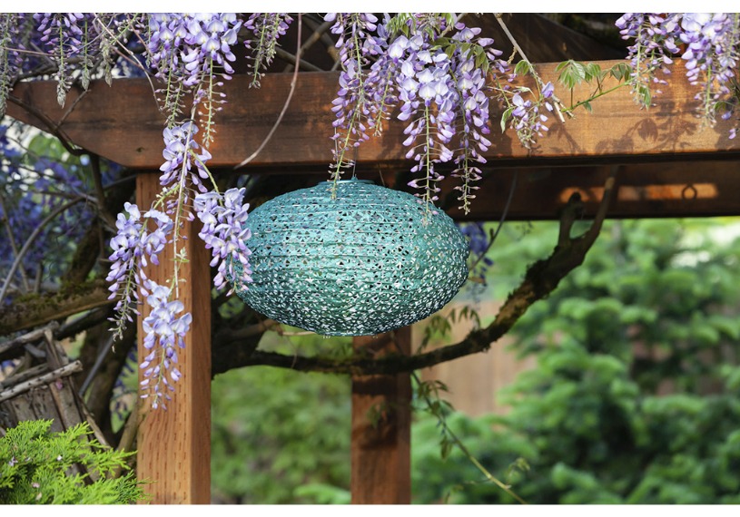 Blue lantern hanging on a wooden pergola