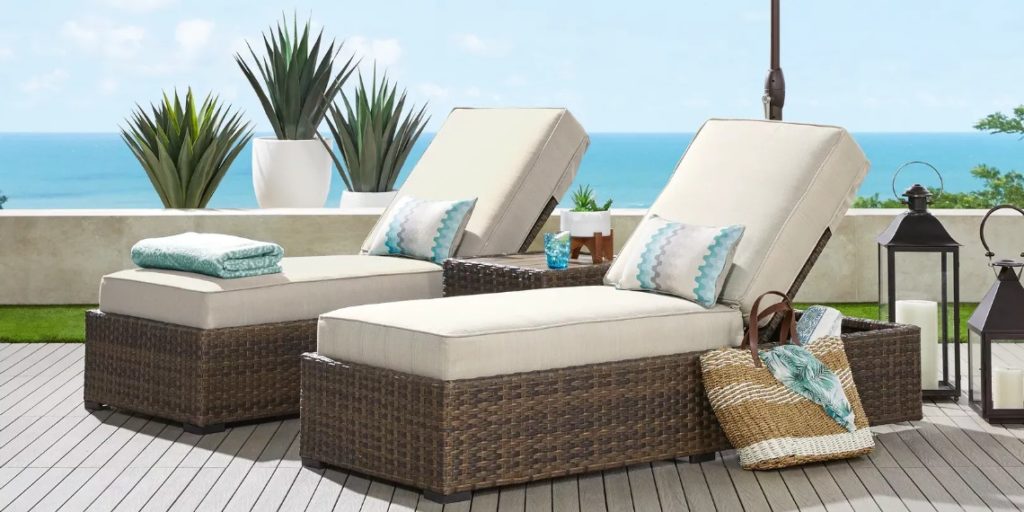 Two outdoor chaise lounges with wicker base and white cushions