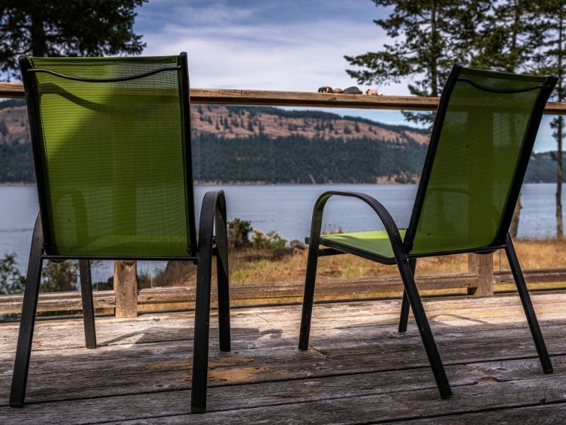 photo of two green sling chairs on a deck