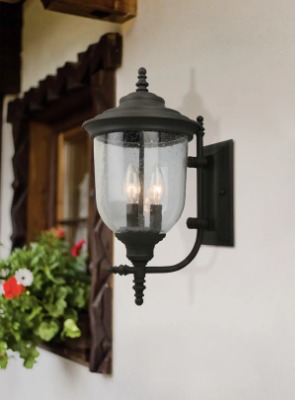 Black sconce on the outside of  a tan house