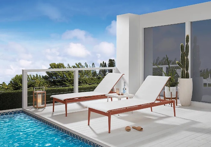 Image of 2 white chaises next to a pool